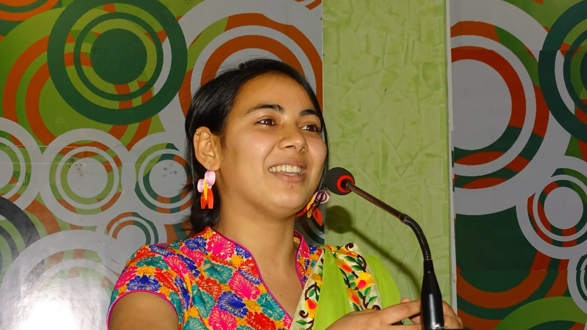 Pestalozzi International Nepal Alumni Arju Dahal giving a speech in a colourful dress