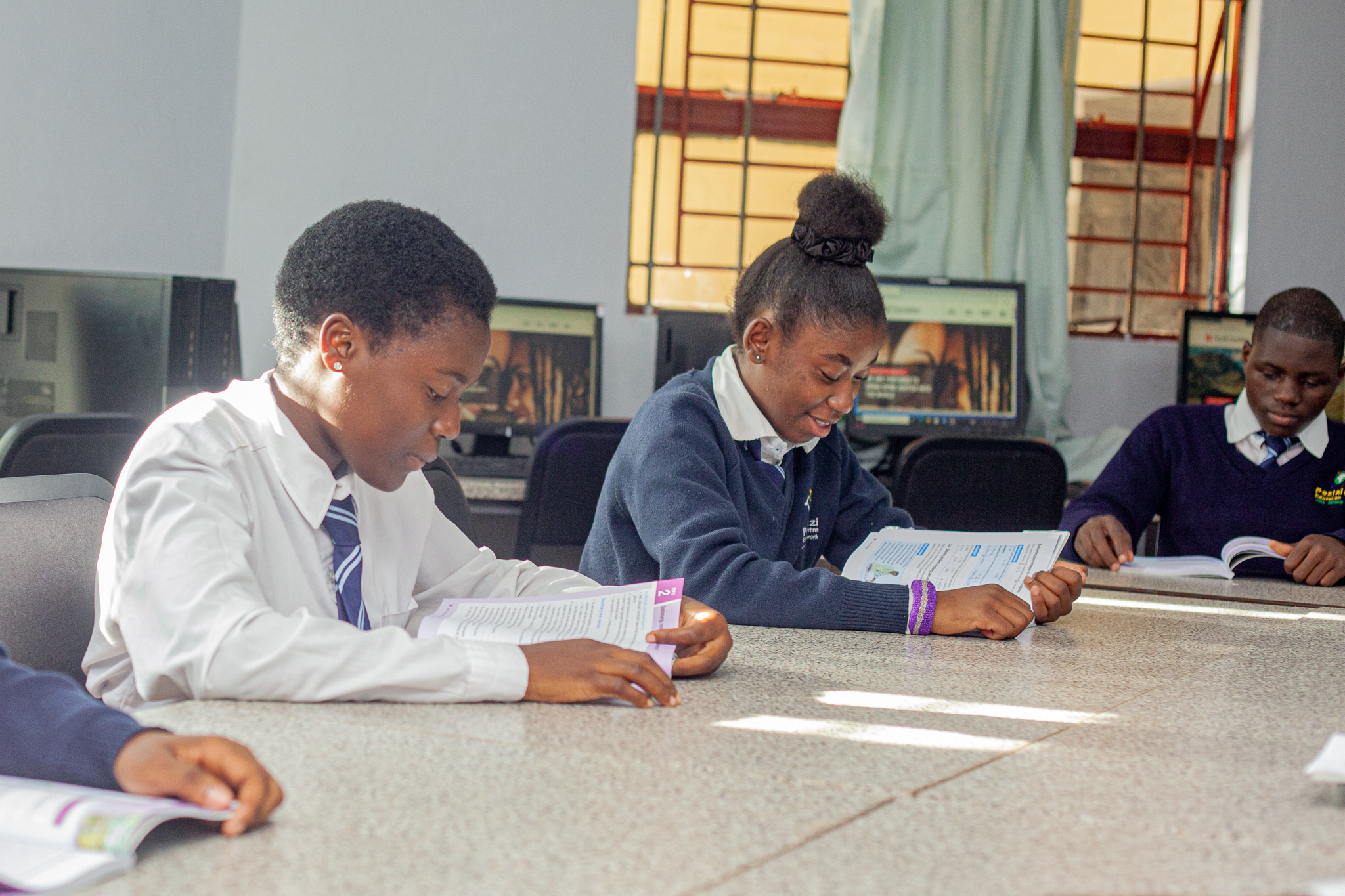 Children learning with books on their tables at Pestalozzi Zambia