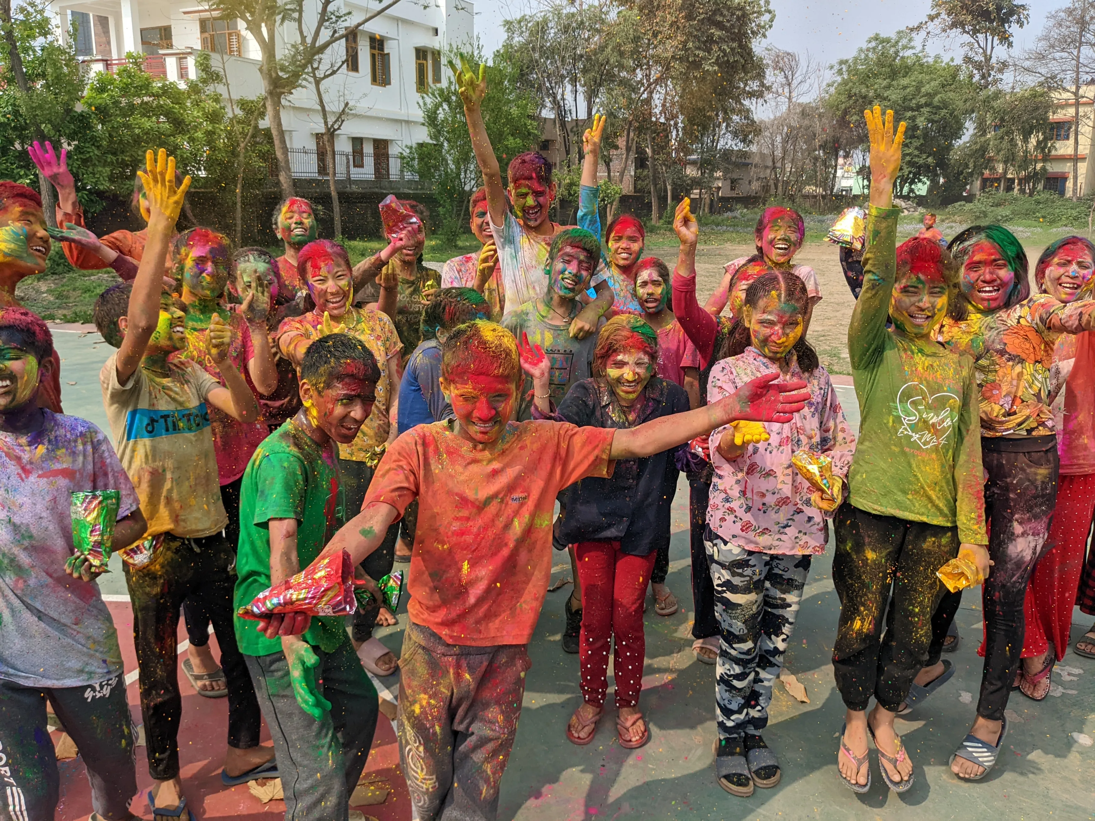 A group of children celebrating the Hindu festival, Holi that celebrates spring, love, and new life. Children covered in powder paint to celebrate the festival of colours.