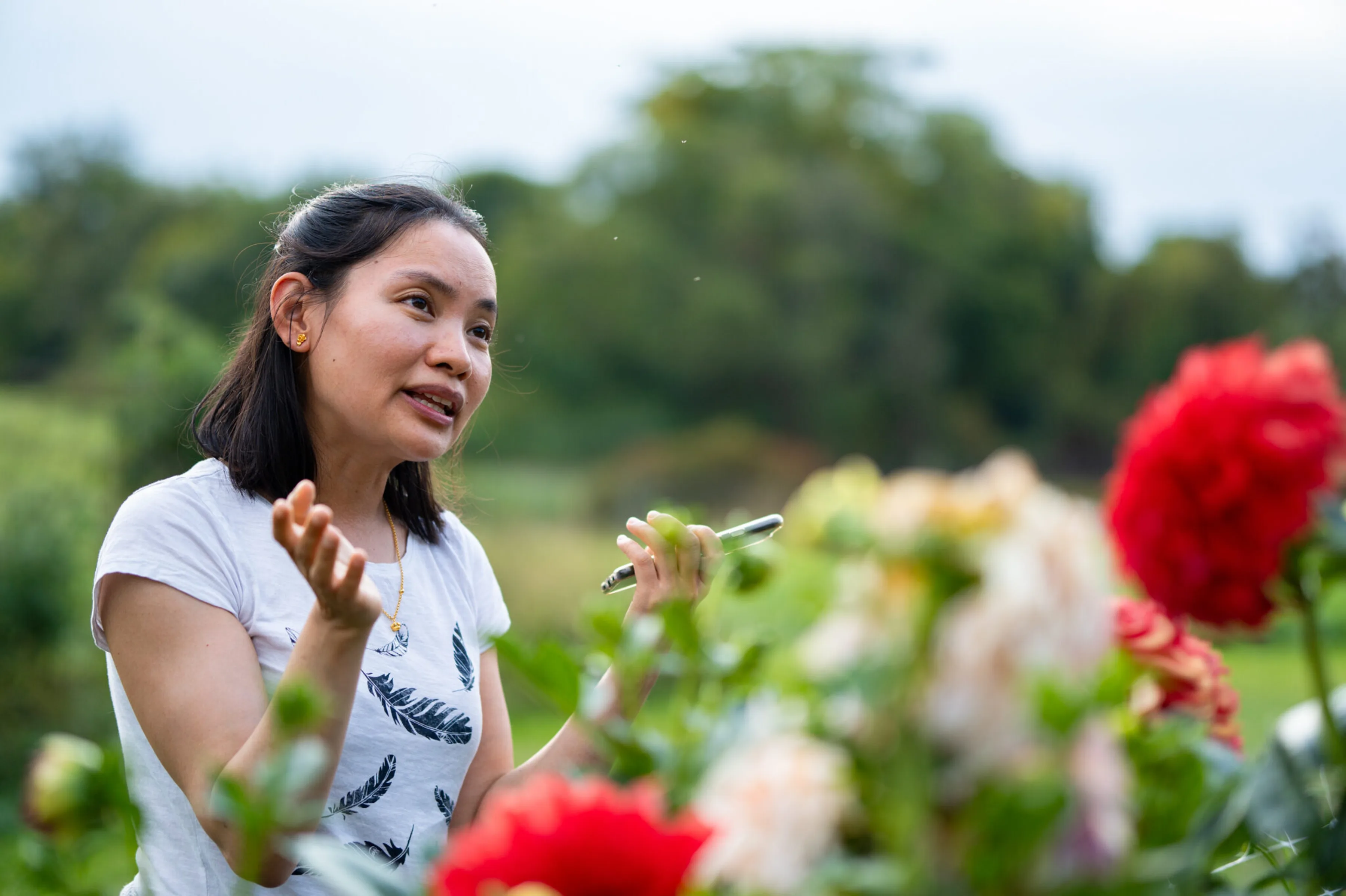 Female Alumni talking behind flowers