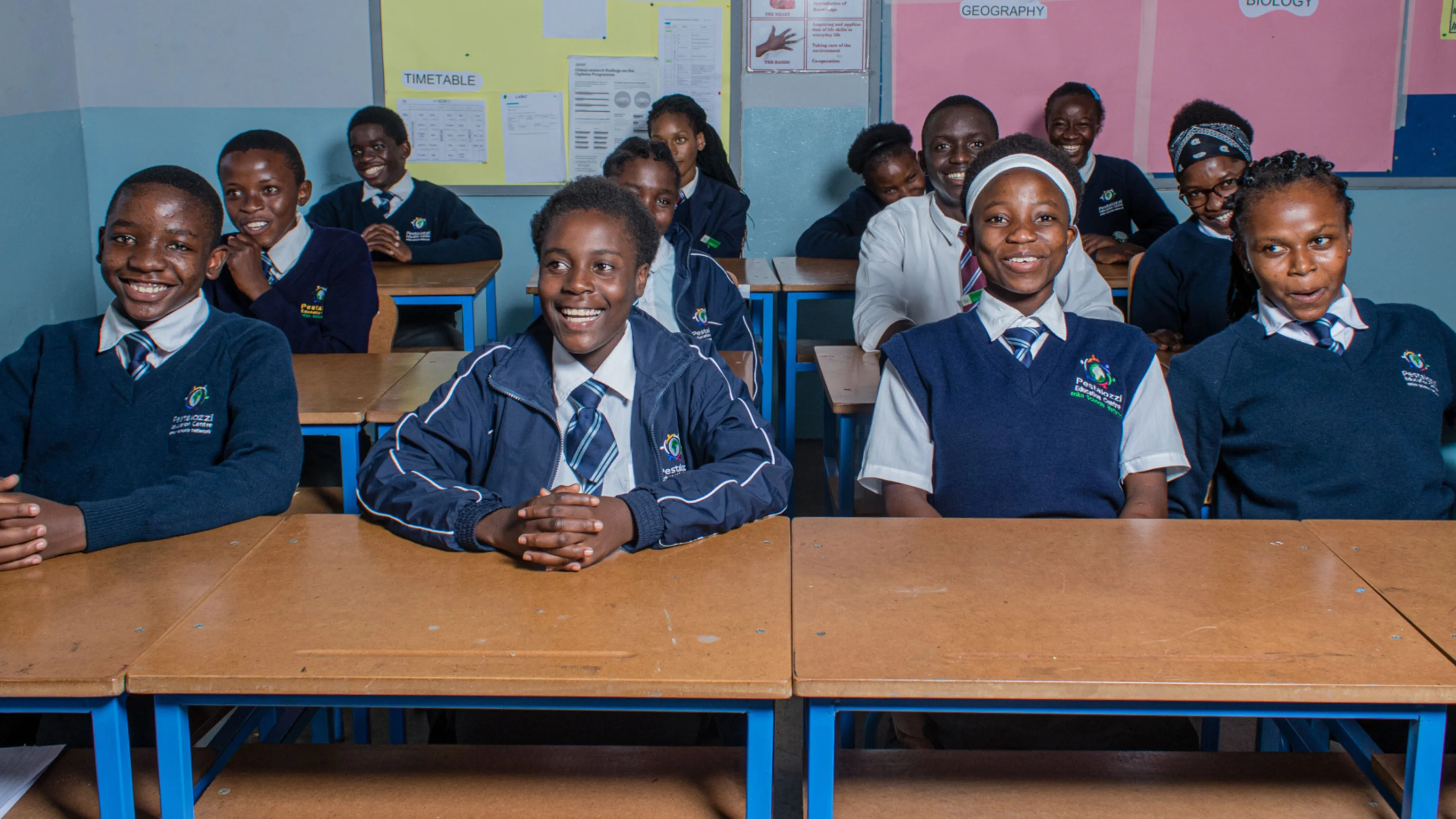 Students in classroom smiling, students from Pestalozzi Zambia Campus