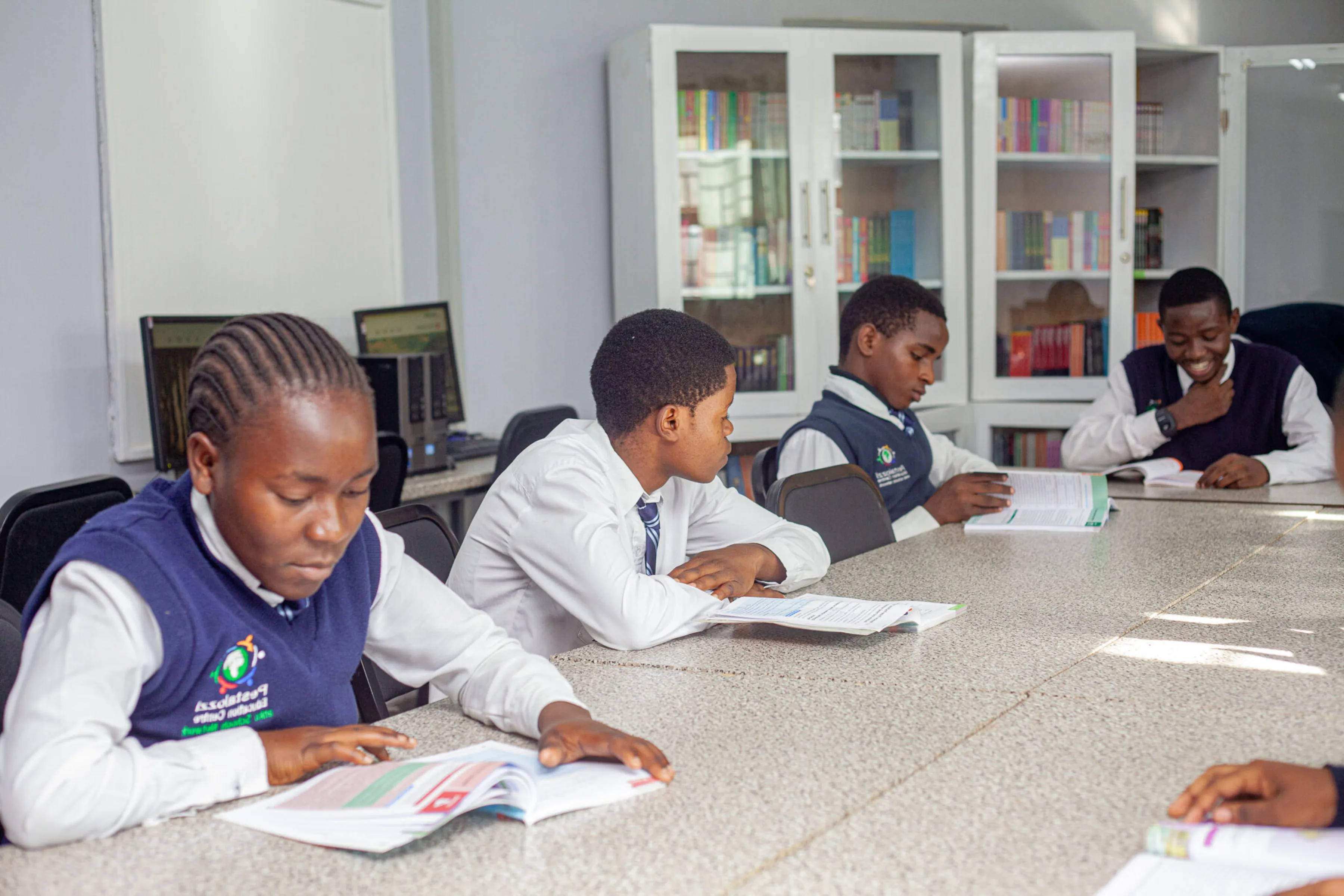 Pestalozzi students sitting around a conference table and reading