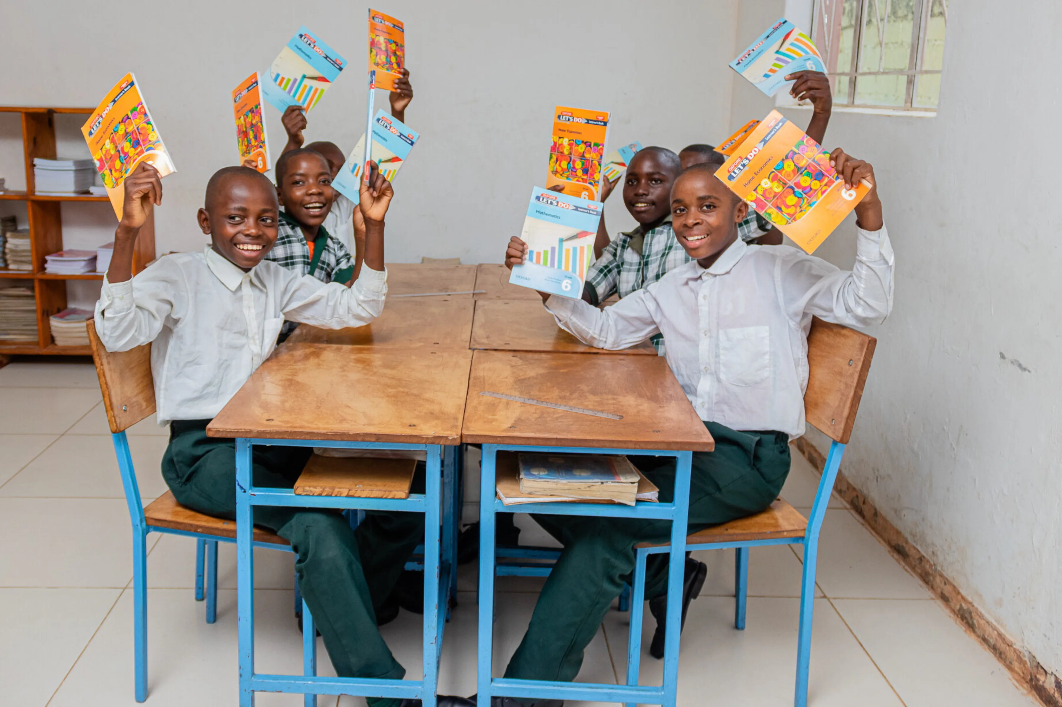 Boys in class at Pestalozzi Campus Zambia holding up books