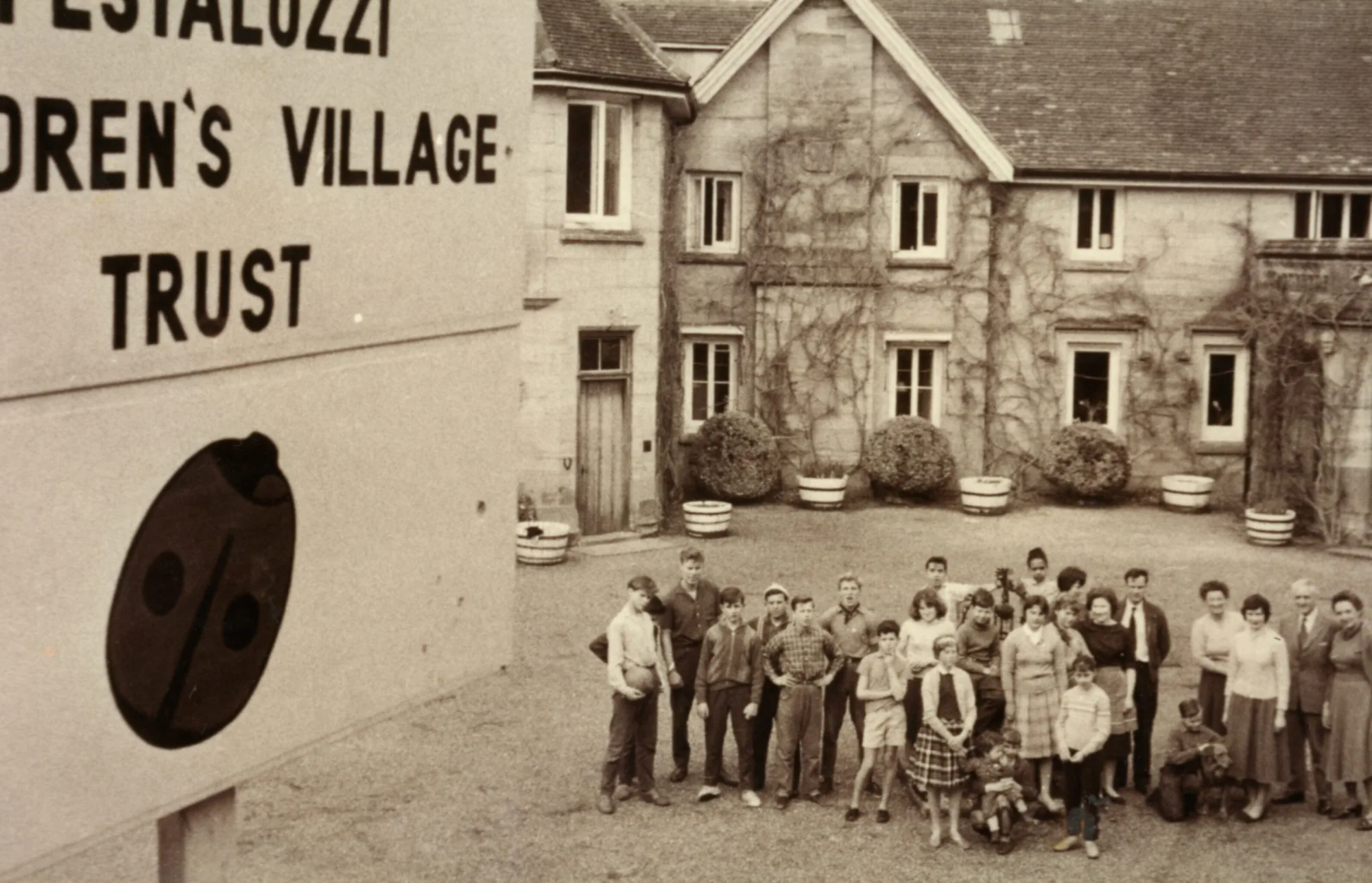 A group of people in the schoolyard of the Pestalozzi village in England