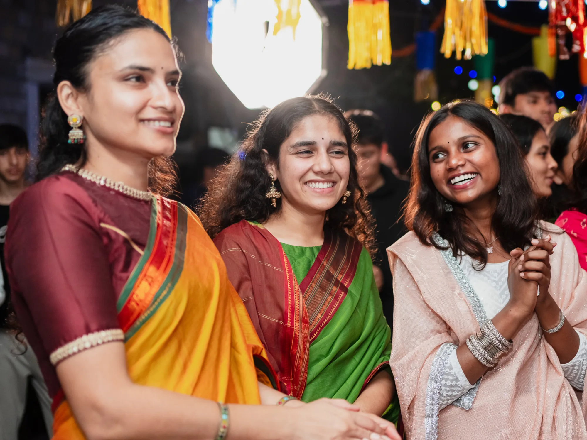 Image of Alumni Shelja with two female students celebrating.